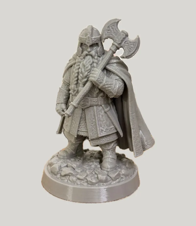Grey figurine of a bearded dwarf holding a double-headed axe