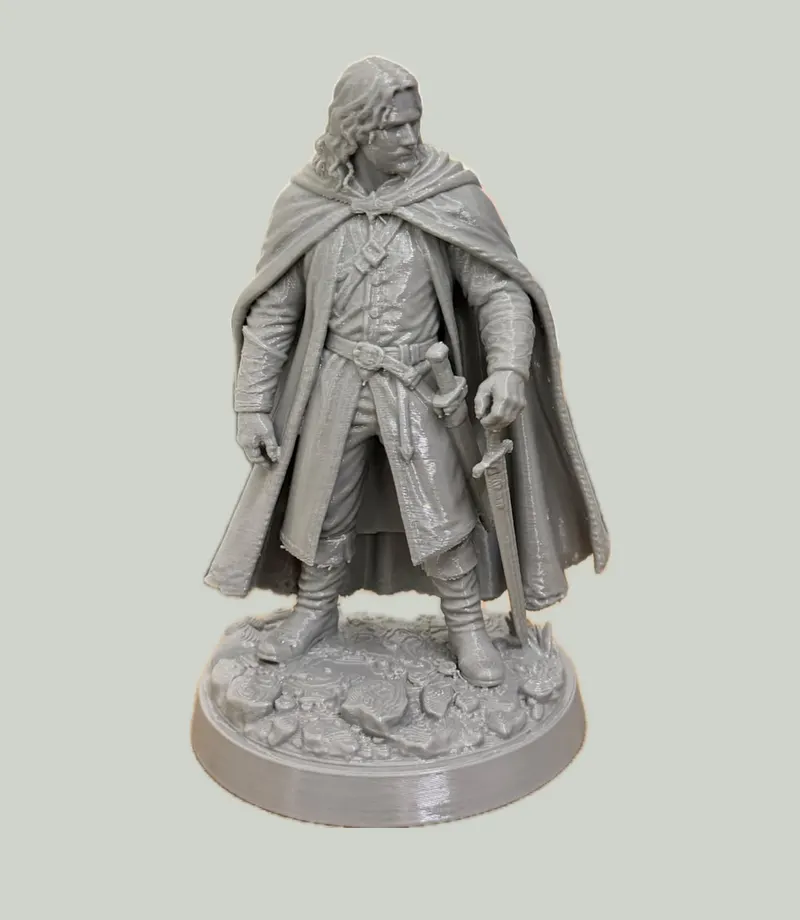 Grey figurine of a cloaked ranger with a sword