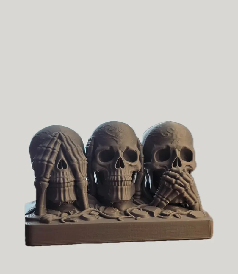 Dark grey trio of skulls covering their eyes, ears and mouth